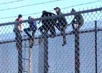 Inmigrantes utilizan una escalera de cuerda para escalar el muro fronterizo en Texas