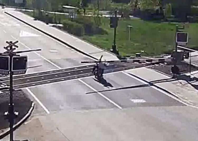 (Video) Un motociclista cae sobre los rieles y lo salvan milagrosamente ante la llegada de un tren