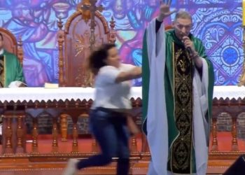 (VIDEO) Una mujer tira al suelo a un sacerdote en plena misa