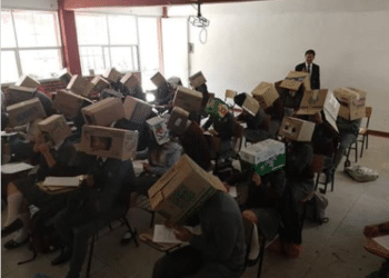 Un profesor coloca cajas de cartón en la cabeza de alumnos para evitar que copien