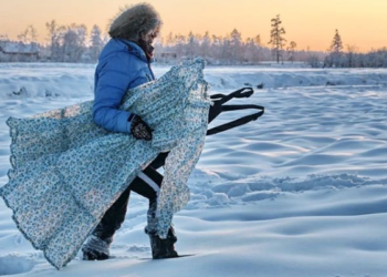 Una mujer muestra la ropa congelada por el frío de Siberia
