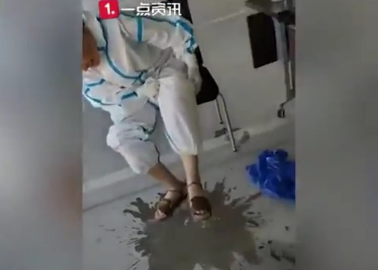 Trabajadora sanitaria china saca sudor de traje protector de Covid-19 en su descanso