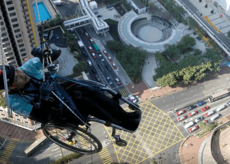 (VIDEO) Un alpinista en silla de ruedas escala más de 250 metros de un rascacielos en Hong Kong