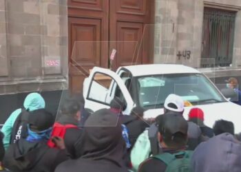 (VIDEO) Normalistas de Ayotzinapa rompen puerta de Palacio Nacional en plena Mañanera de AMLO